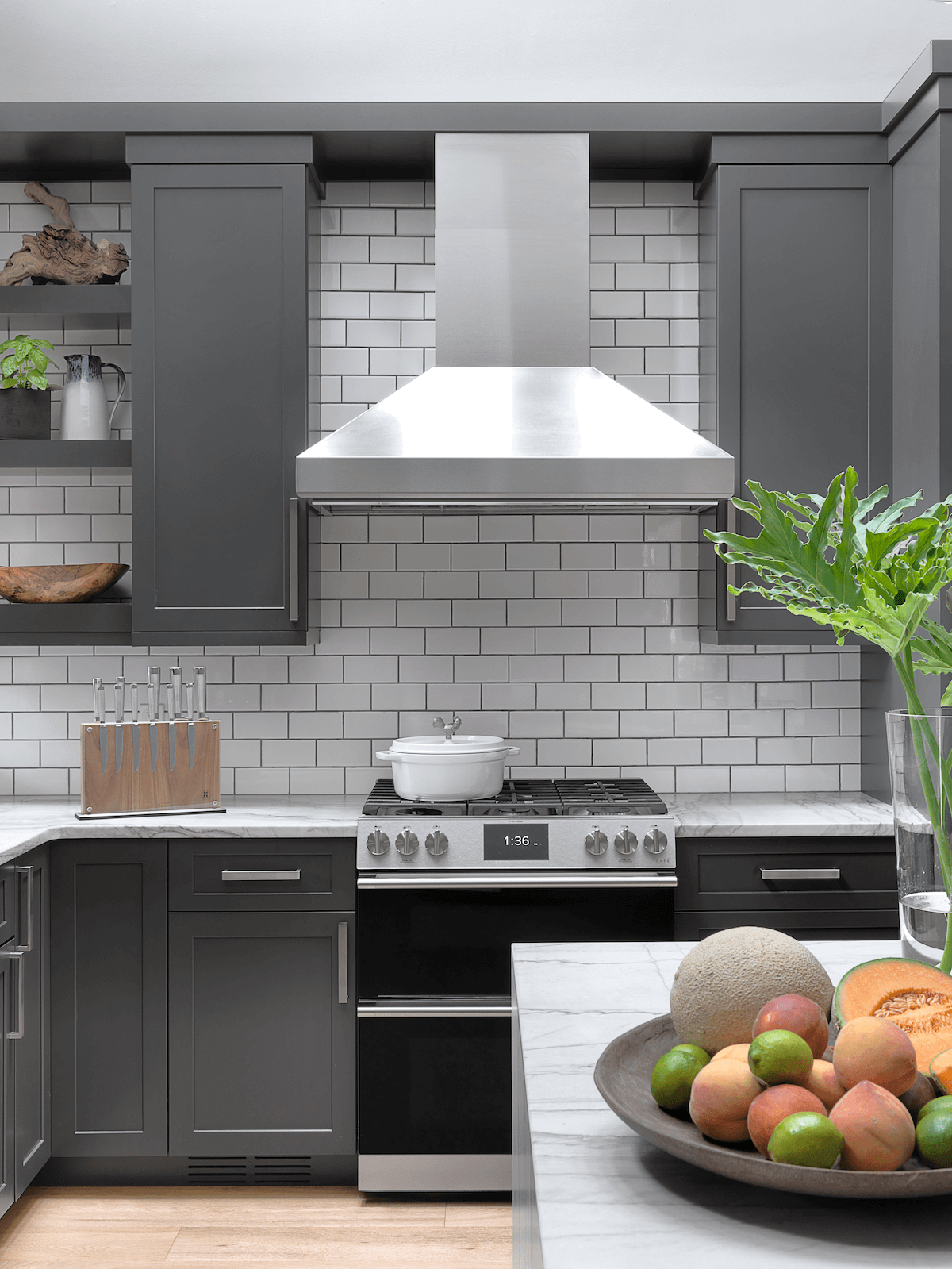 Modern kitchen with cooktop, steel hood and subway tile