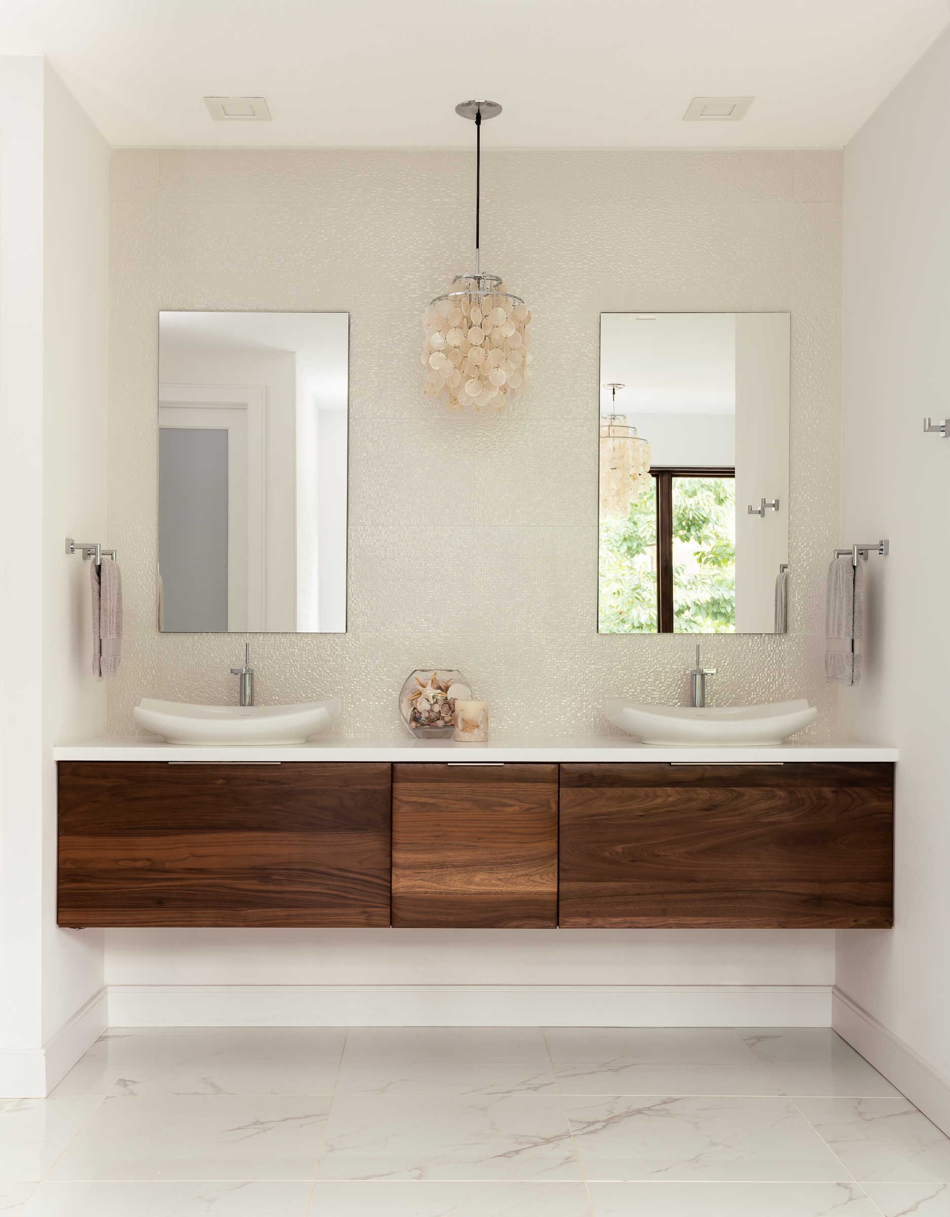 Walnut slab drawer fronts make a statement on a modern floating vanity design by Beck/Allen Cabinetry.
