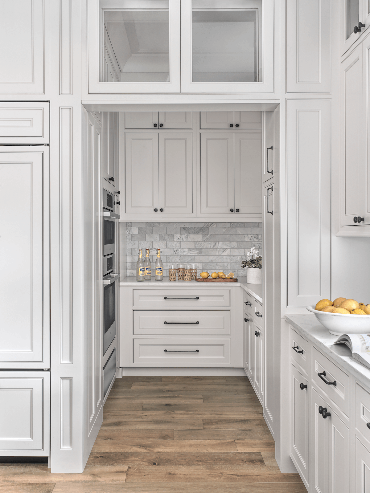 A recessed butler's pantry featuring white cabinets from Beck/Allen Cabinetry. Design by Diane Breckenridge Interiors.